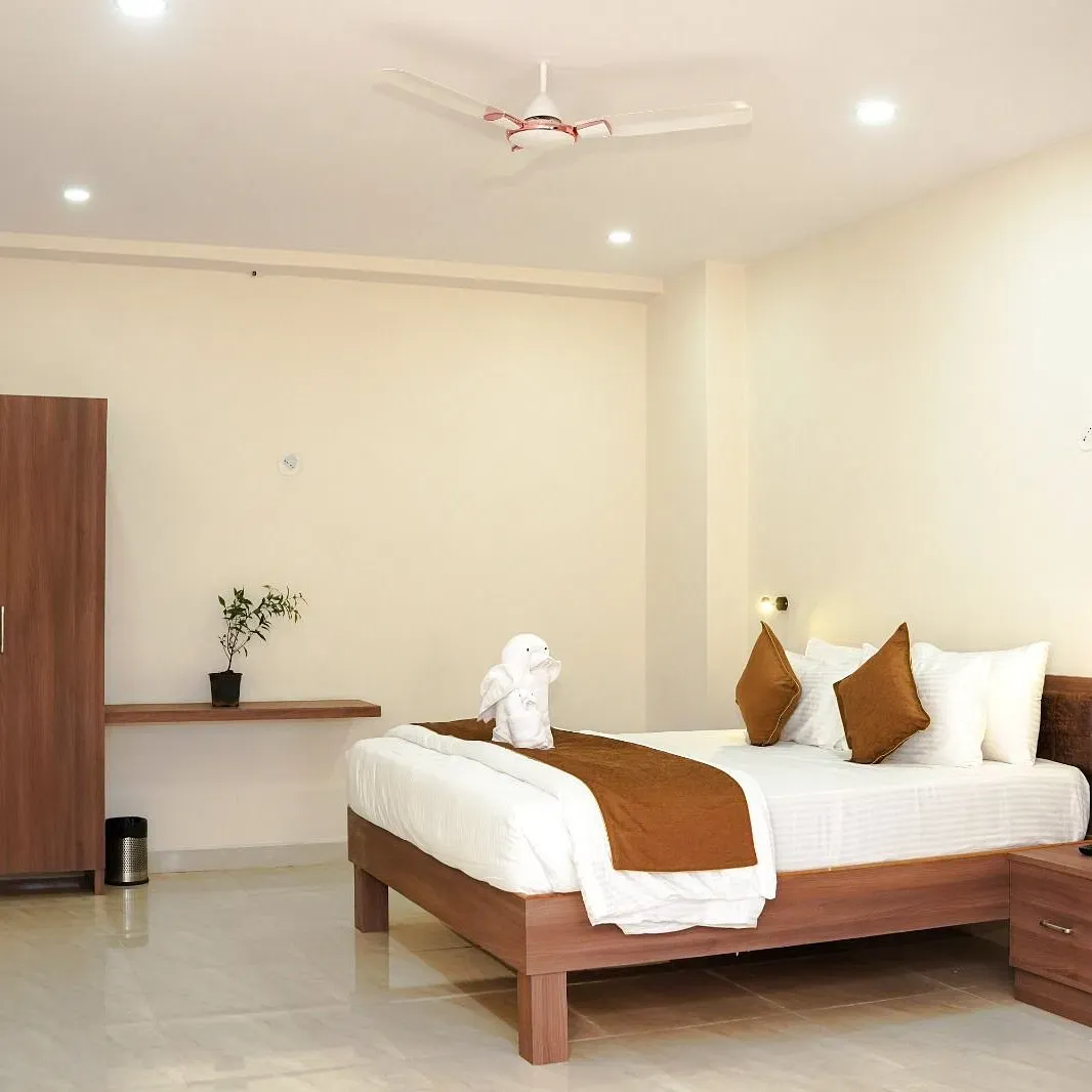 Well-lit room with a double bed and a wardrobe at ANS M Square Hotel & Resort, Kalaburagi