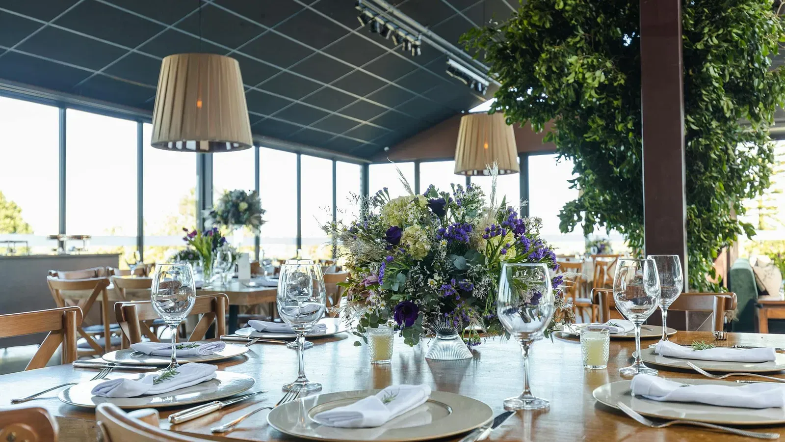 Image of a banquet hall with cutlery; and lights hanging from the ceiling