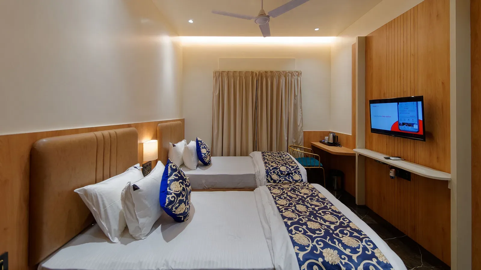 Twin beds and a television in a room at M Square Hotels & Resorts
